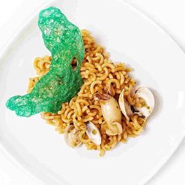 Plato de fideuá con calamares y almejas.