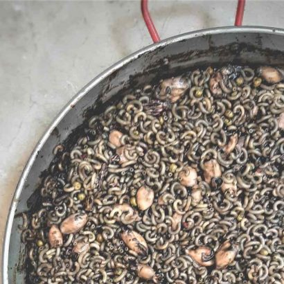 Fideuá de puntillas en su tinta con guisantes